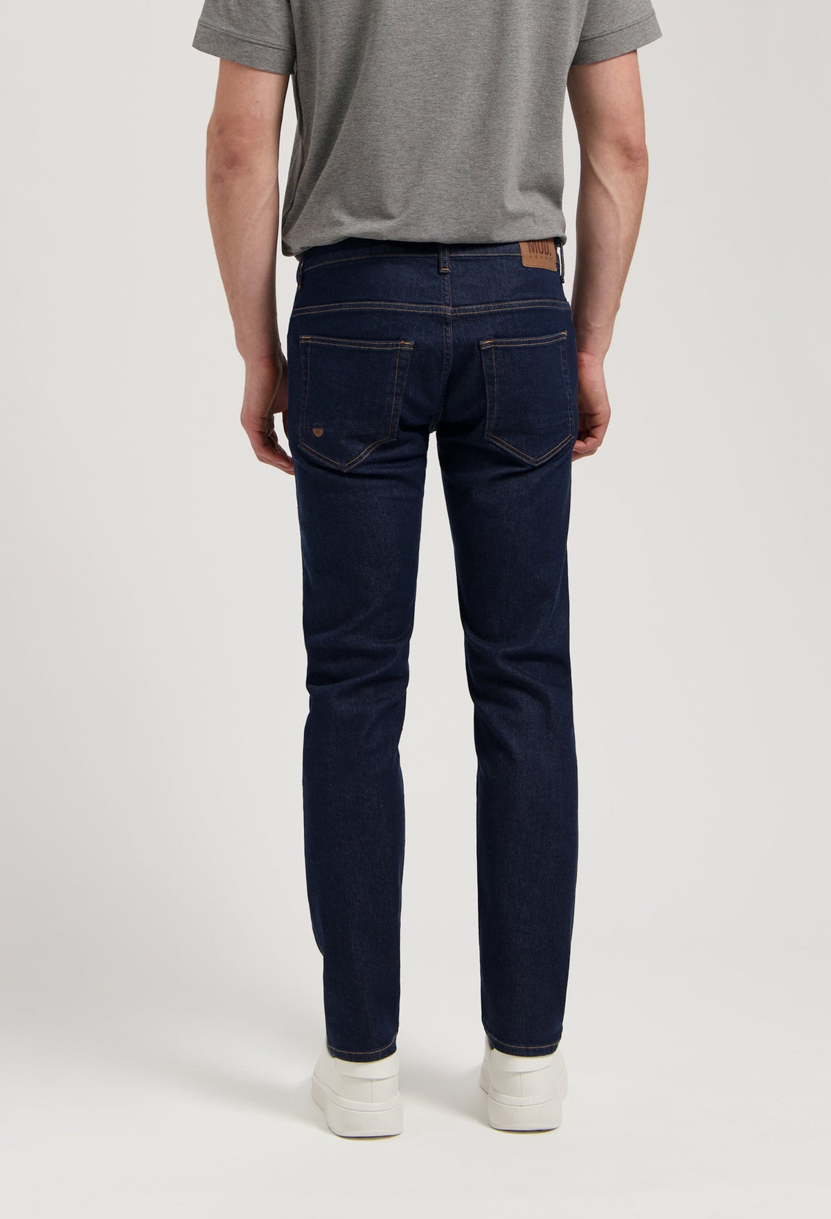 Sustainable MUD Jeans in dark denim paired with a cozy gray sweater, showcasing ethical fashion for modern style.