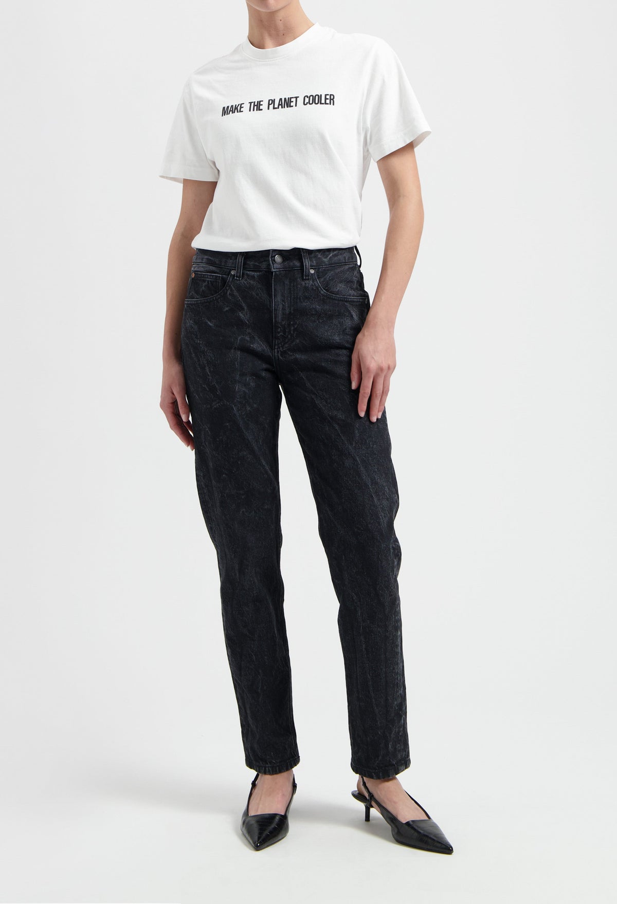 Casual white t-shirt with "Make the Planet Cooler" slogan, paired with black acid-washed jeans and black pointed heels.