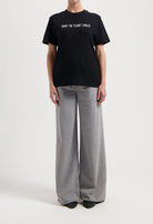 Sustainable MUD Jeans in dark brown, crafted with ethical materials, shown in a slim fit, paired with a casual white tee.