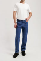 Sustainable MUD Jeans in dark gray denim, slim fit, showcasing ethical fashion paired with black leather shoes.