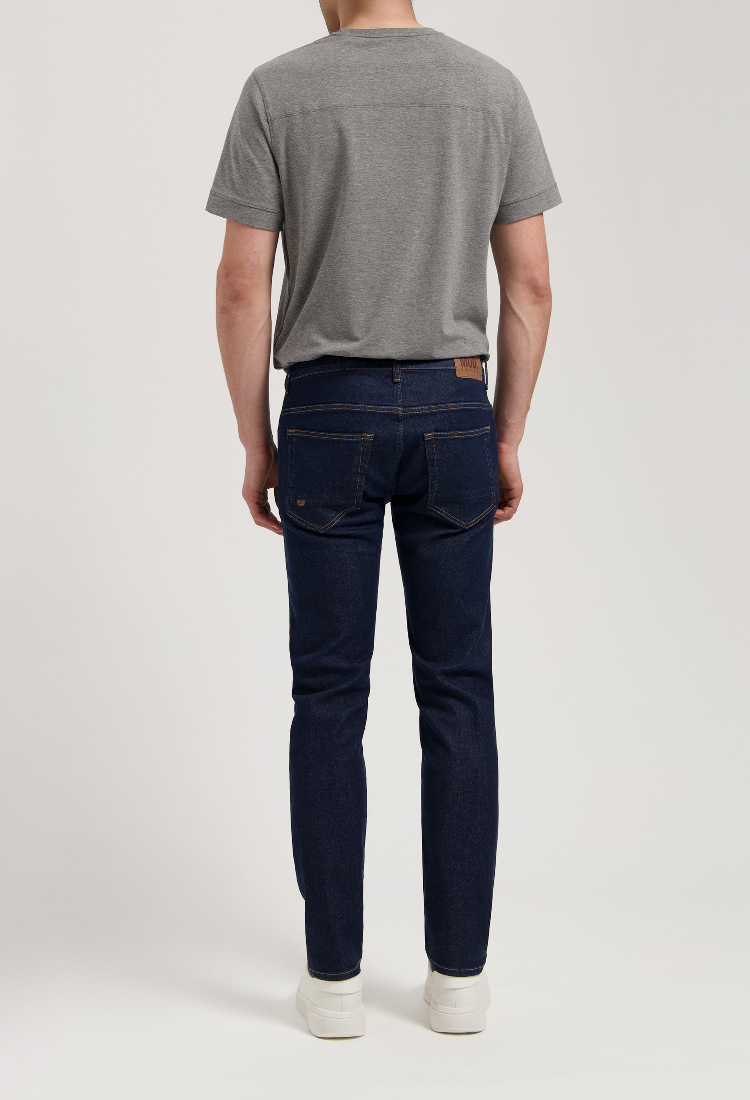 Sustainable MUD Jeans made from organic cotton, styled with a gray sweater, offering a timeless and ethical fashion choice.