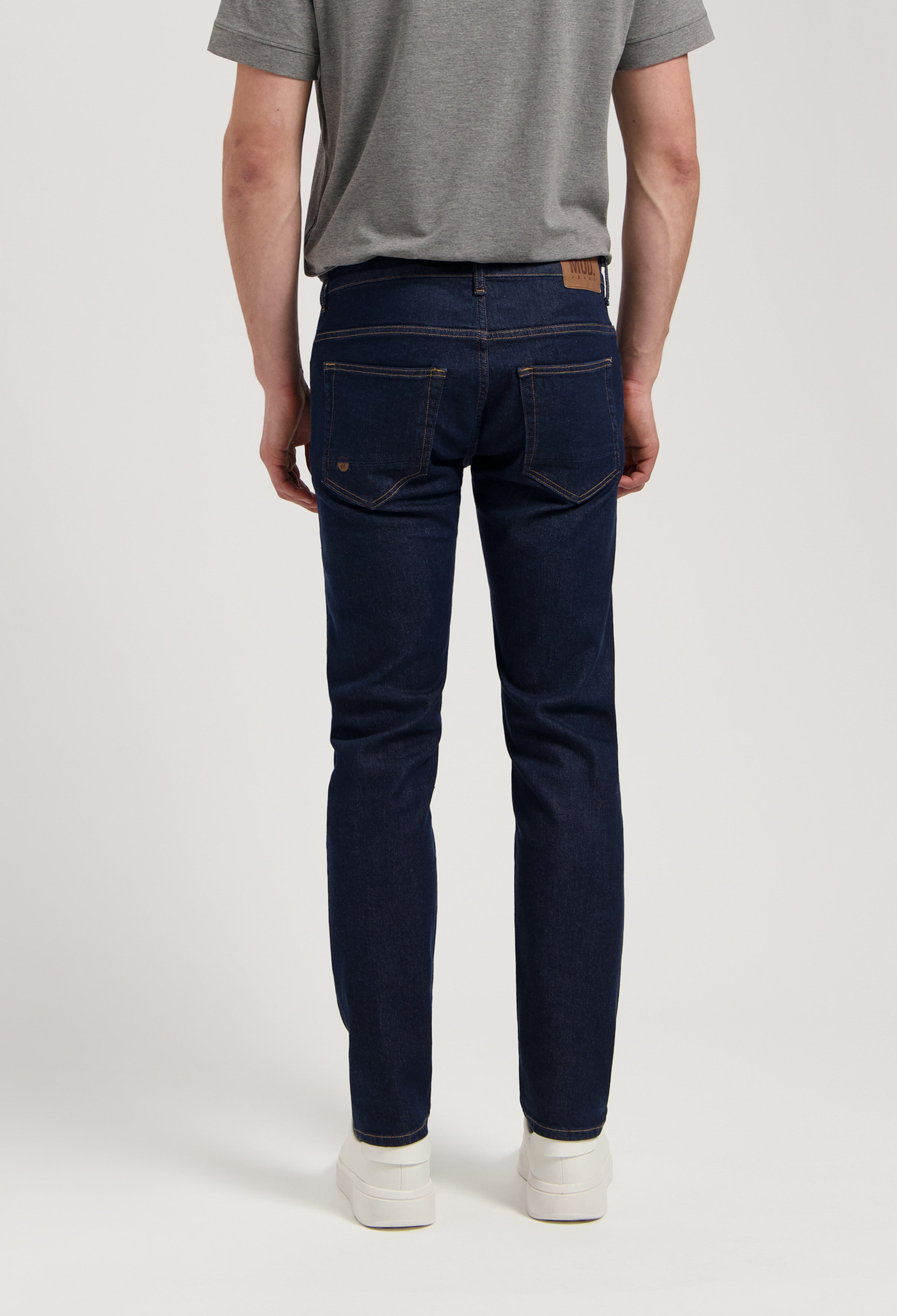 Sustainable MUD Jeans in dark denim paired with a cozy gray sweater, showcasing ethical fashion for modern style.