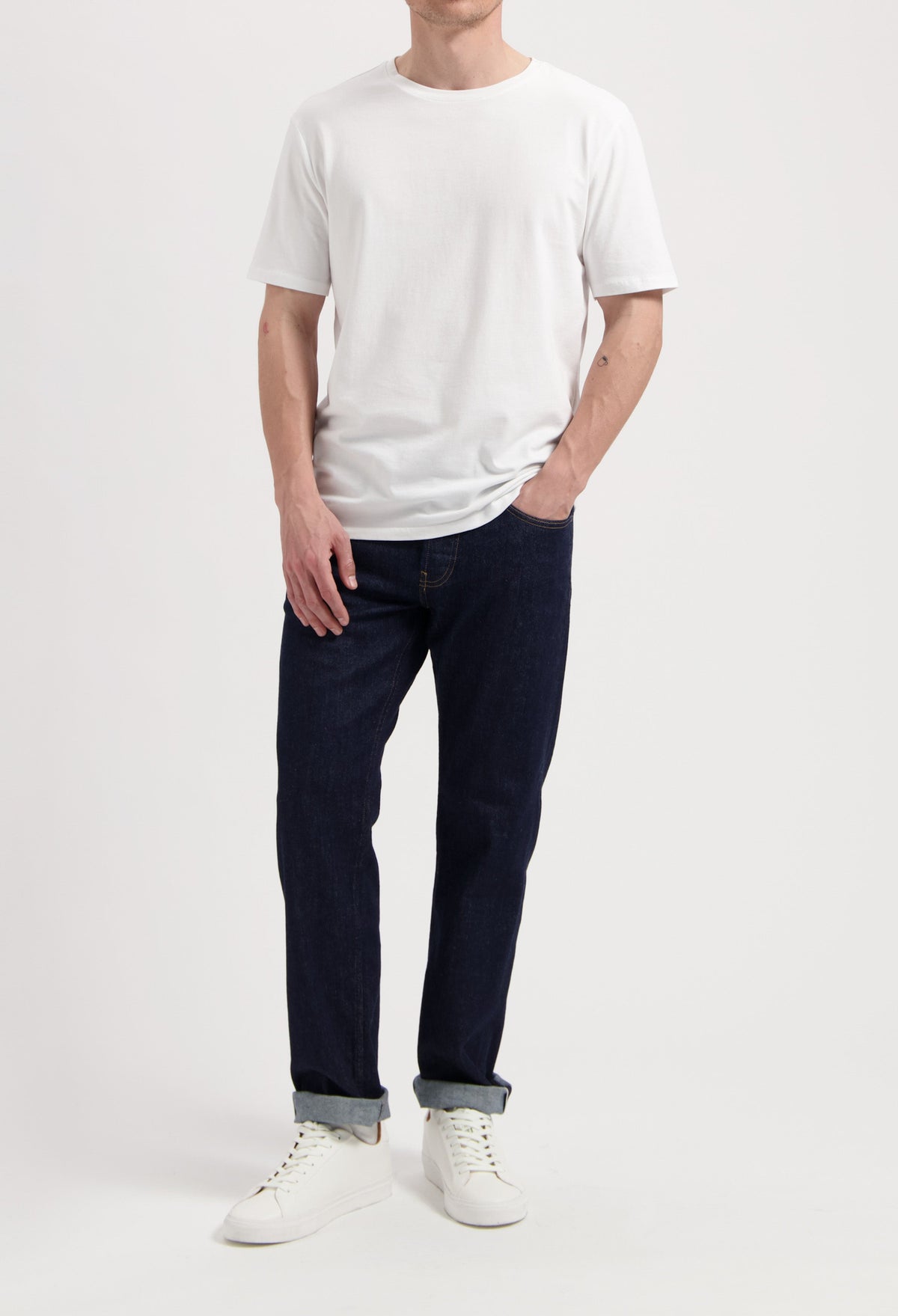Sustainable MUD Jeans ensemble with dark denim jacket, light blue jeans, and white sneakers, embodying ethical fashion.