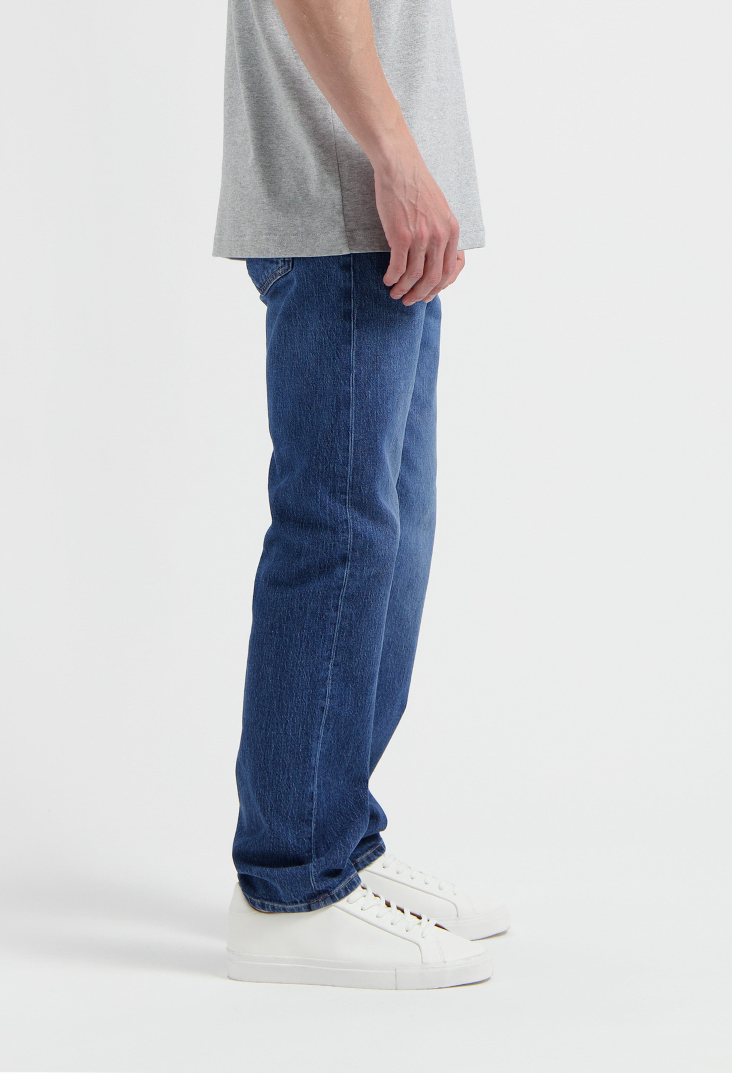 Sustainable MUD Jeans in dark blue denim, showcasing ethical craftsmanship and style, paired with white sneakers.