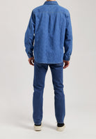 Sustainable MUD Jeans in dark denim, featuring a straight fit with ethical craftsmanship, paired with a white top.