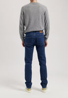 Sustainable MUD Jeans in dark denim, ethically crafted for a modern fit, styled with white shirts and minimalist footwear.