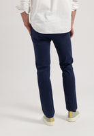 Sustainable MUD Jeans in dark gray denim, made from organic cotton, paired with black sneakers for an ethical look.