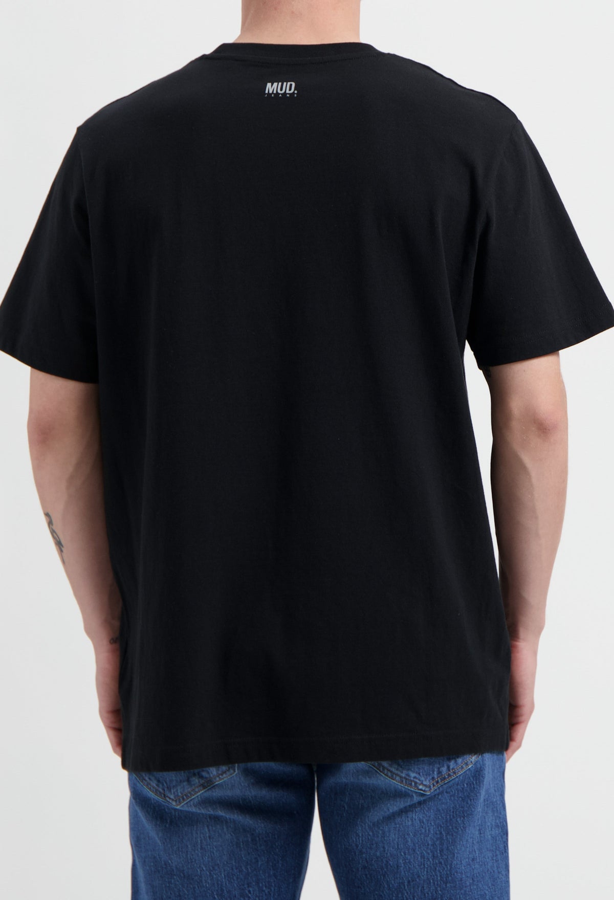 Sustainable MUD Jeans made from organic cotton, featuring stylish gray denim, worn with a black shirt.