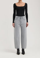 Casual high-waisted gray wide-leg jeans paired with a fitted black long-sleeve top and sleek black ankle boots.