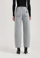 High-waisted light gray jeans with wide-leg cut, showing back view, paired with black long-sleeve top and black boots.