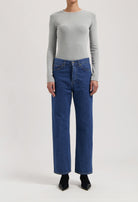 Gray long-sleeve top paired with classic high-waisted blue denim jeans, showcasing casual chic fashion style.