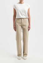 Casual beige straight-leg pants paired with a white short-sleeve top, highlighting relaxed fit and minimalist style.