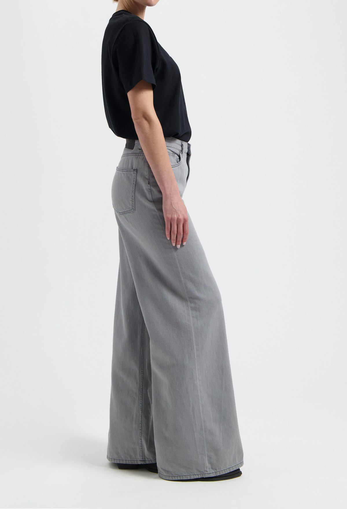 Wide-leg gray denim jeans paired with a simple black short-sleeve T-shirt, showcasing casual style for everyday wear.