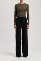 Olive long-sleeve fitted top paired with high-waisted black wide-leg jeans, showcasing casual and chic fashion style.