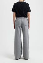 Sustainable MUD Jeans in beige, crafted from organic cotton, offering a tailored fit, paired with a gray T-shirt.